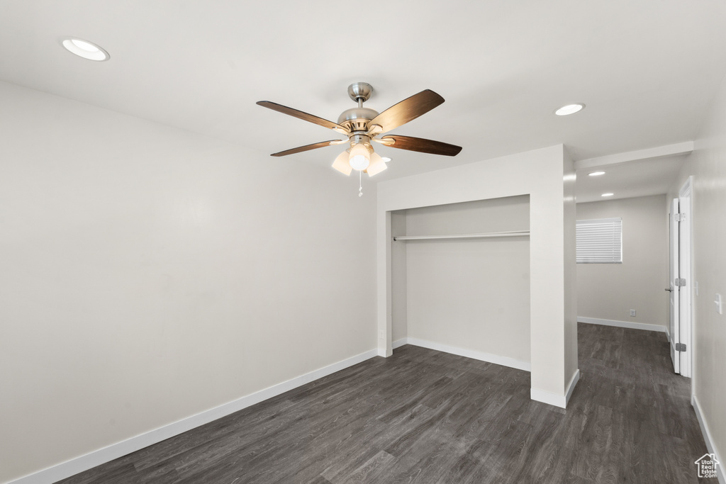 Unfurnished bedroom featuring dark wood-style flooring, a closet, baseboards, recessed lighting, and a ceiling fan