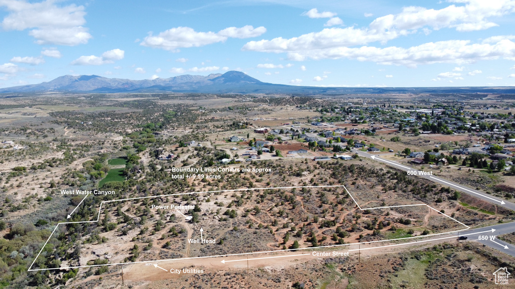 Aerial overview of property's location with a mountainous background and property boundaries highlighted