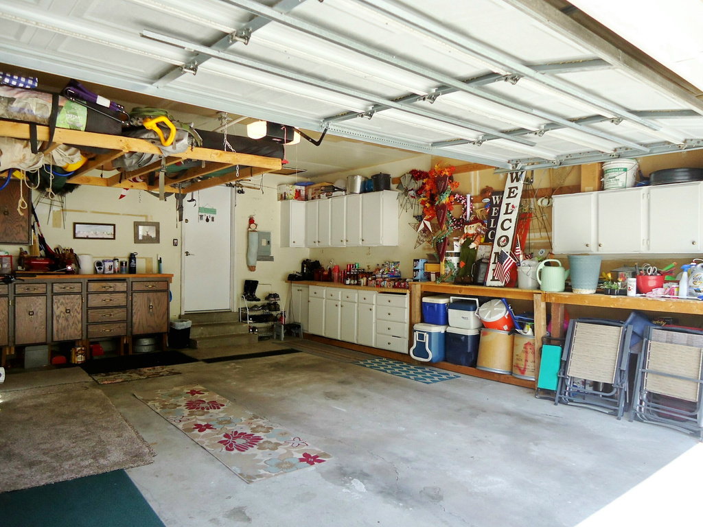 Garage with a workshop area, electric panel, and a garage door opener