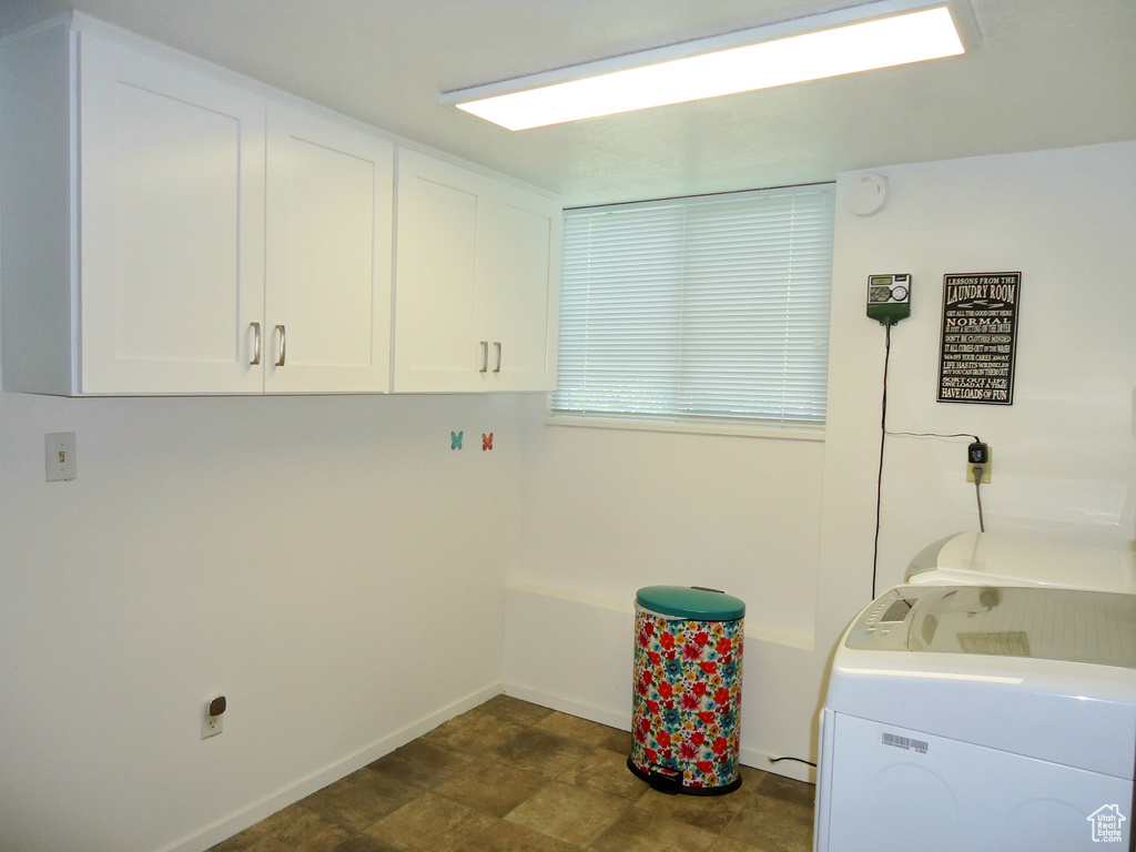 Washroom featuring cabinet space, baseboards, and separate washer and dryer