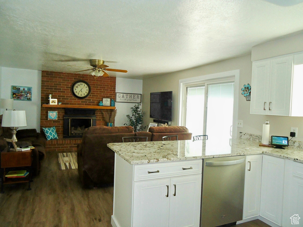 Kitchen with stainless steel dishwasher, a peninsula, ceiling fan, open floor plan, and dark wood-style floors