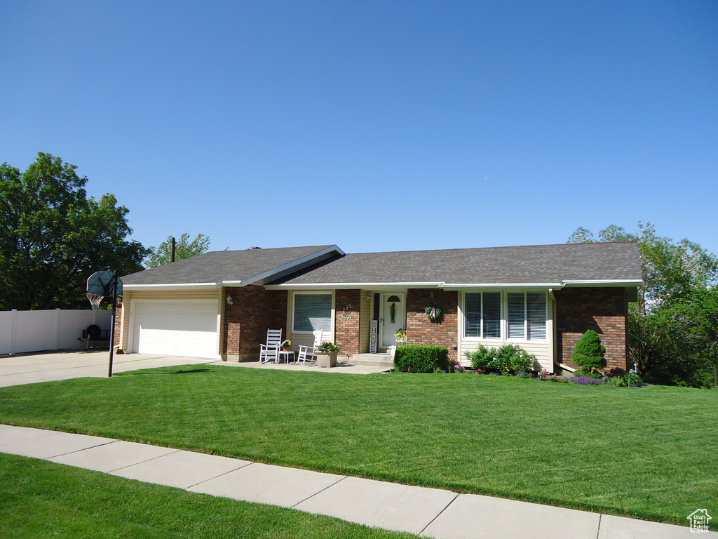 Single story home featuring brick siding, driveway, and an attached garage