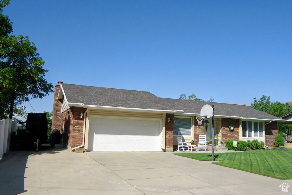 Single story home with driveway, a garage, brick siding, and a chimney