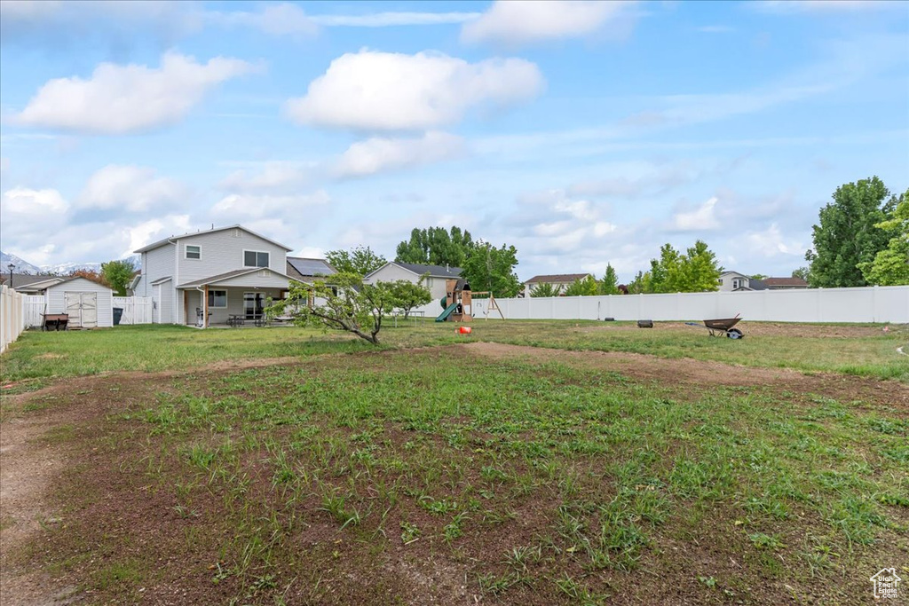 View of yard with a playground, a shed, and an outbuilding