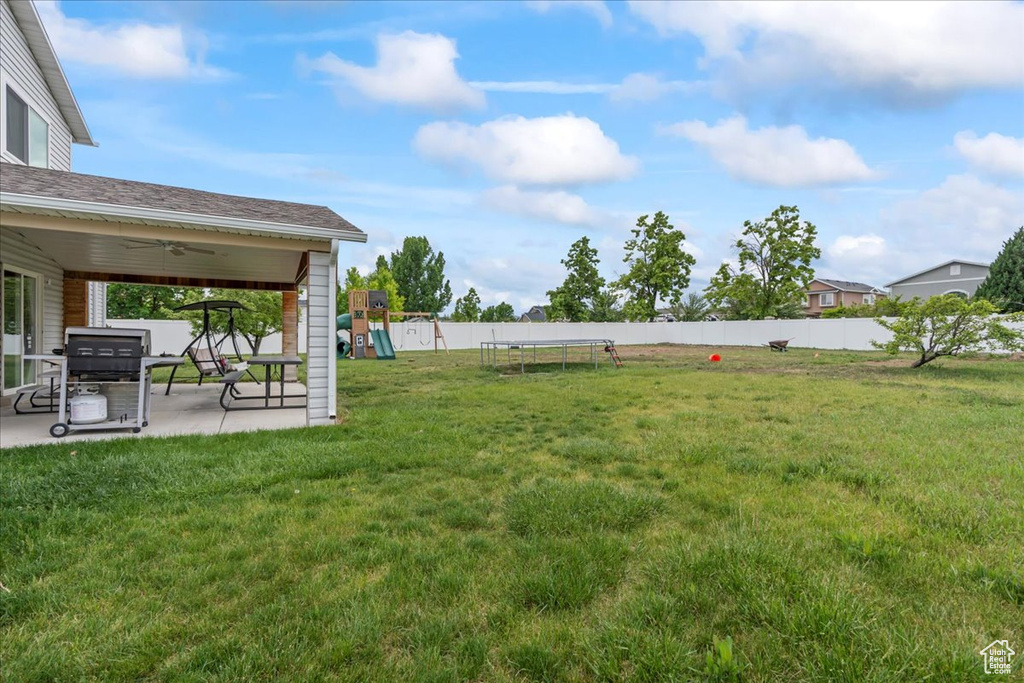 View of yard with a playground, a patio, a ceiling fan, and a trampoline