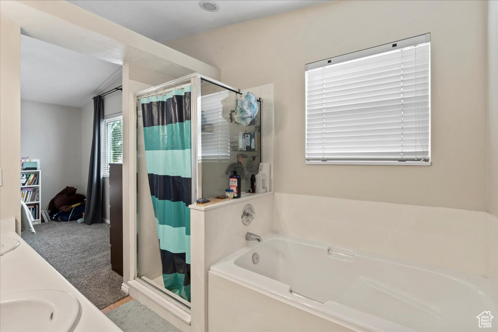 Bathroom featuring a shower stall, a sink, and a bath