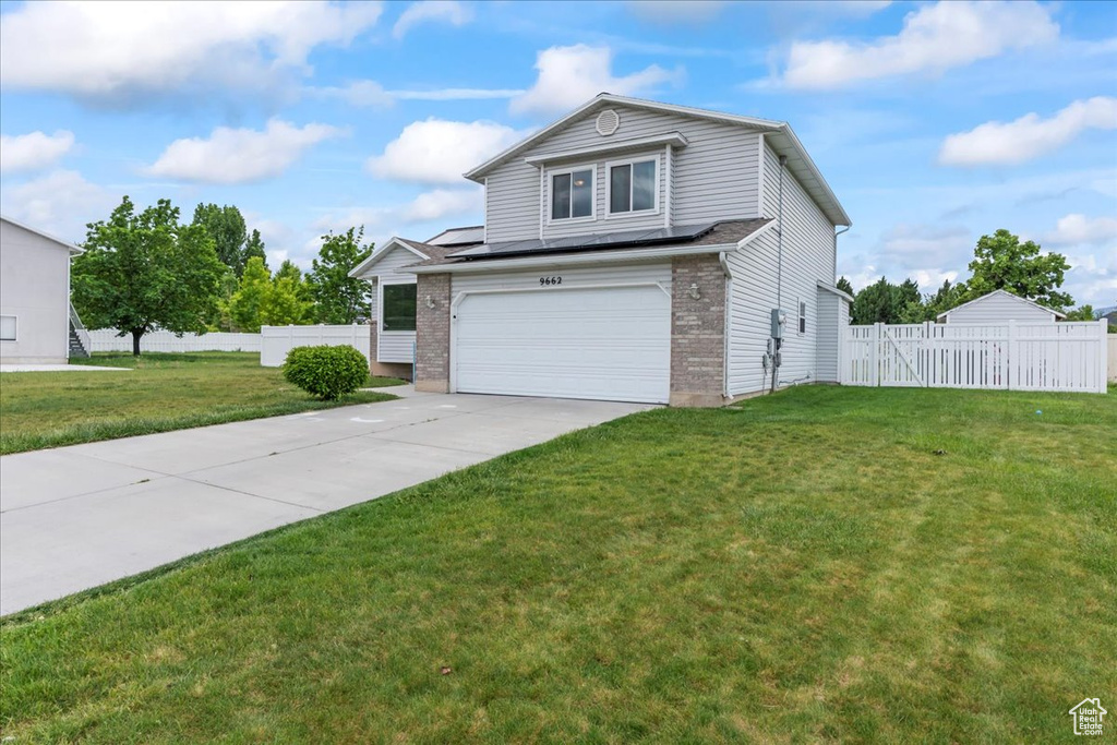 View of front of property featuring an attached garage, driveway, and brick siding