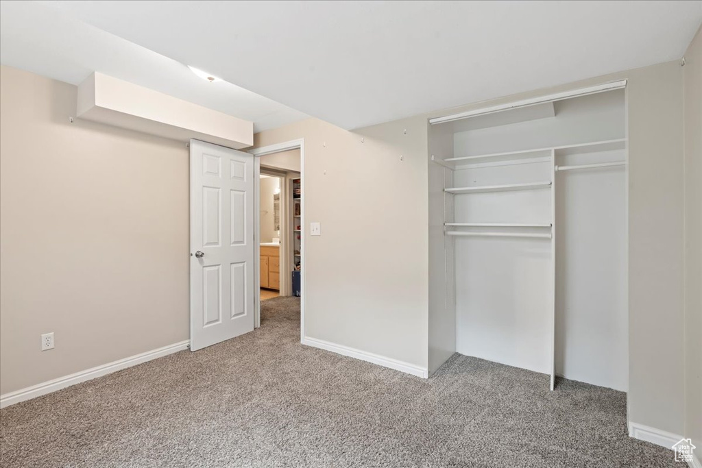 Unfurnished bedroom with carpet flooring, a closet, and baseboards