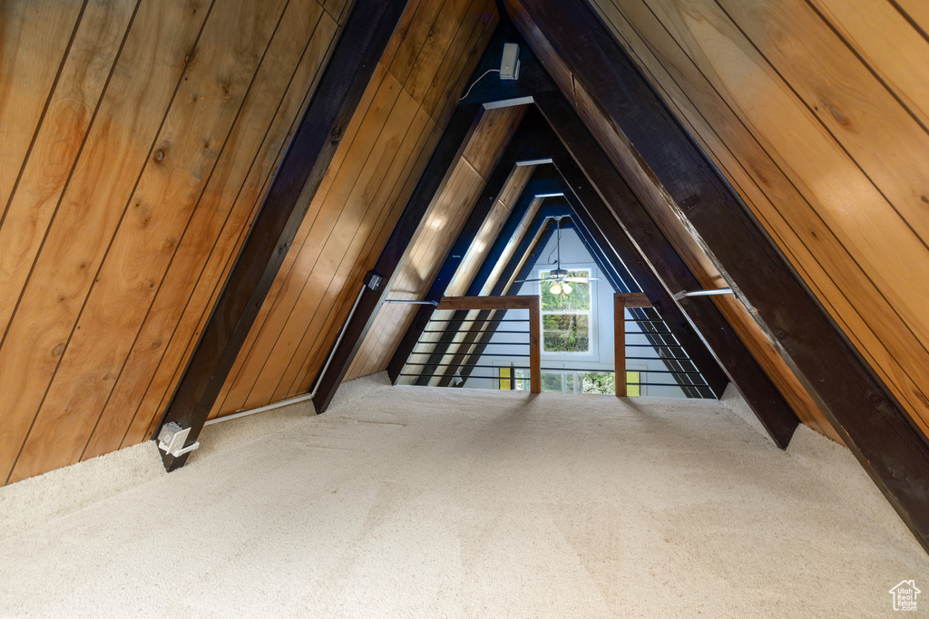 Bonus room featuring carpet floors, vaulted ceiling, and wooden walls