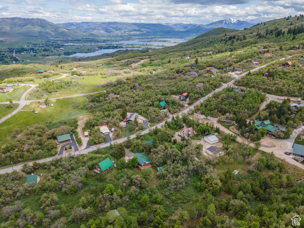 Aerial view of property and surrounding area with a water and mountain view