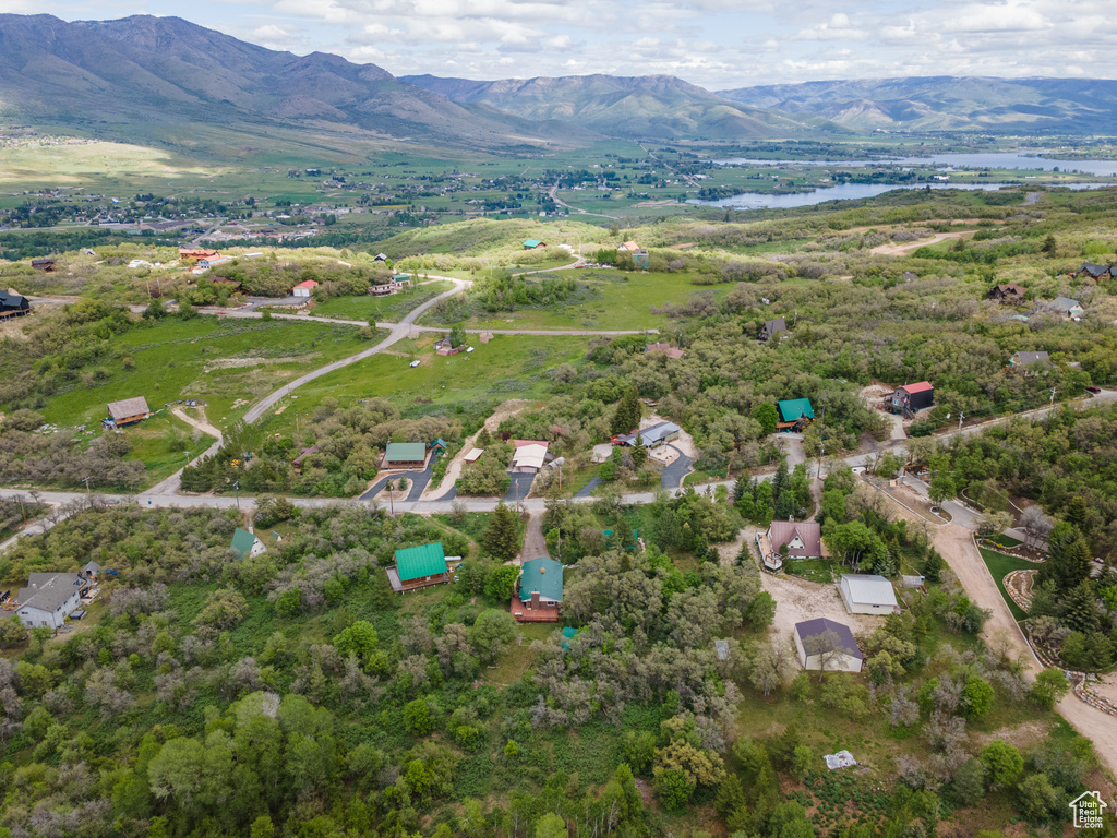Aerial view of property and surrounding area with a water and mountain view