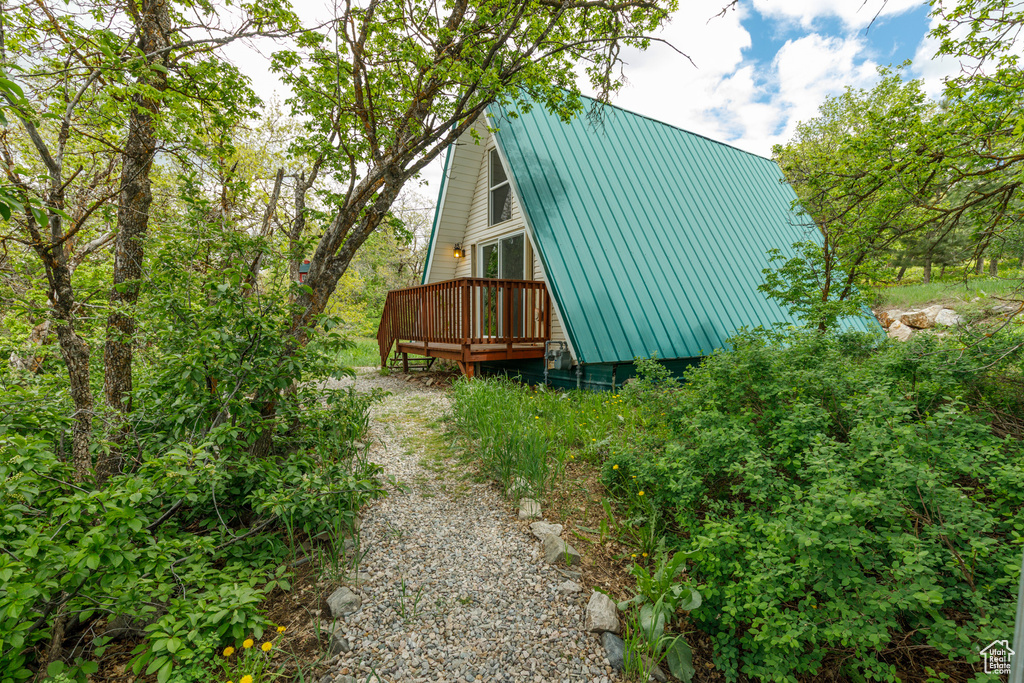View of side of property with a deck and metal roof