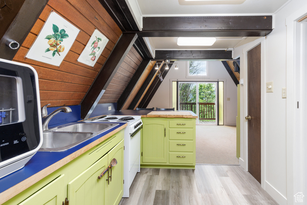 Kitchen featuring green cabinetry, white range with electric cooktop, light wood-style flooring, a sink, and stainless steel microwave