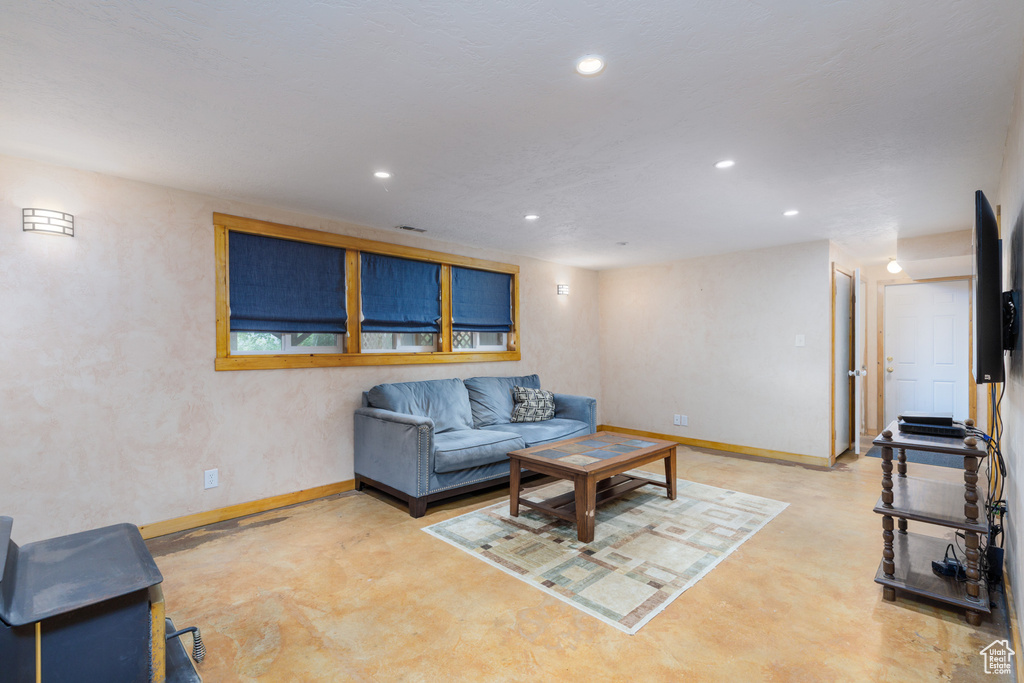 Living area with finished concrete floors, baseboards, and recessed lighting