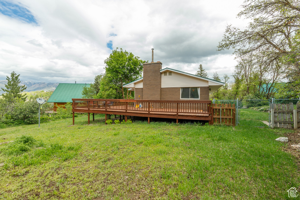 Rear view of property with a wooden deck and a chimney