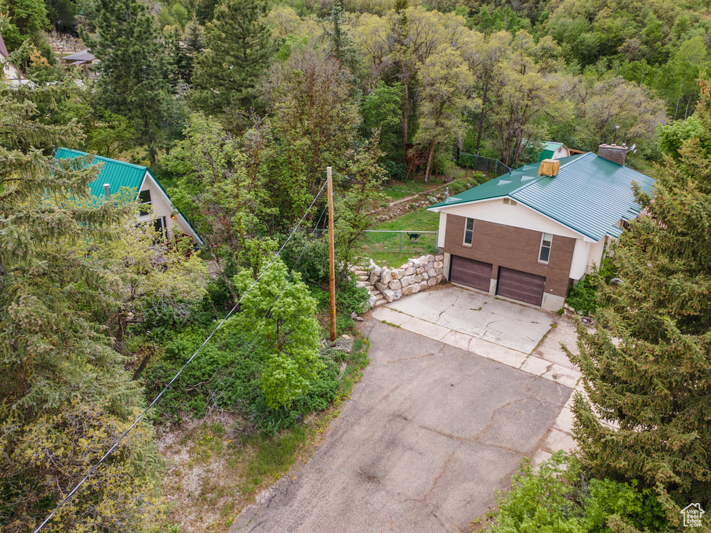 Aerial view of property and surrounding area with a forest