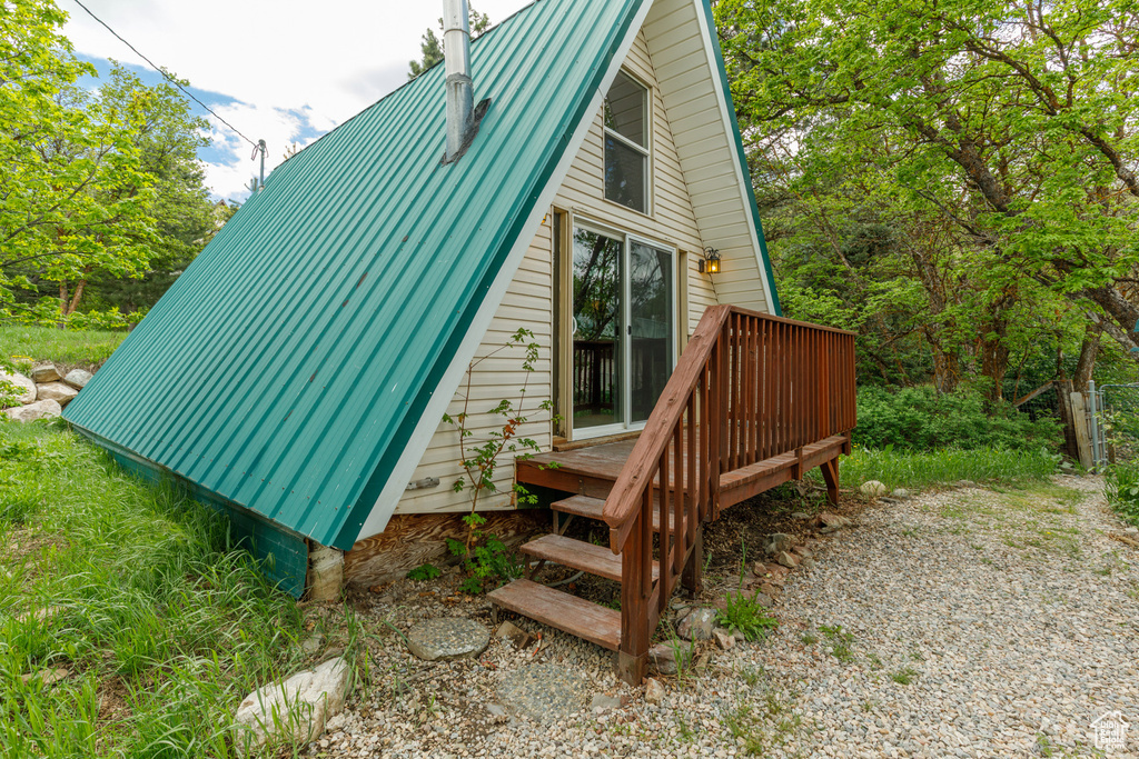 View of side of property with metal roof and a wooden deck