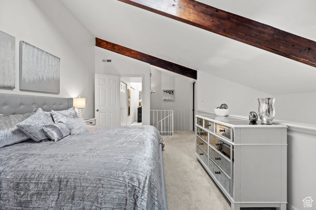 Bedroom with light carpet, lofted ceiling with beams, and visible vents