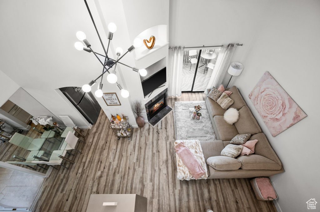 Living room featuring a glass covered fireplace, a chandelier, and wood finished floors