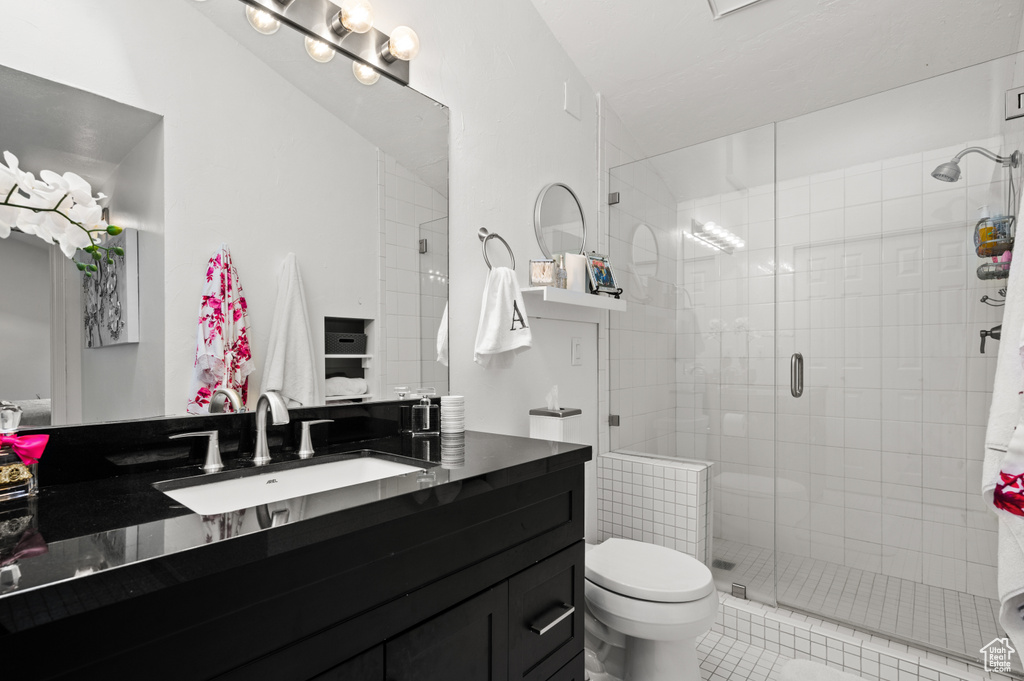 Full bathroom featuring vanity, toilet, tile patterned flooring, and a stall shower