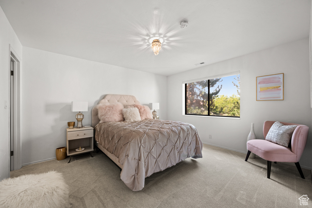 Bedroom featuring light carpet, baseboards, and visible vents