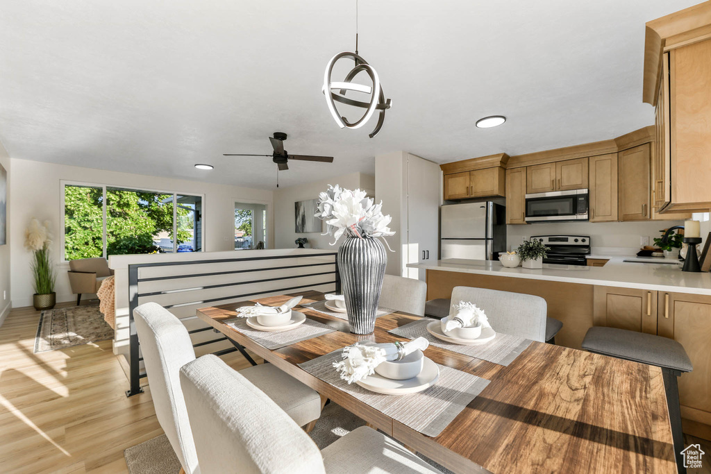 Dining space featuring light wood finished floors, a ceiling fan, and recessed lighting