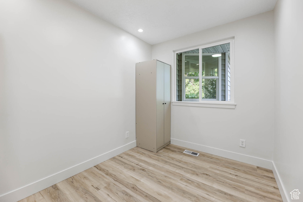 Empty room with baseboards, wood finished floors, and recessed lighting