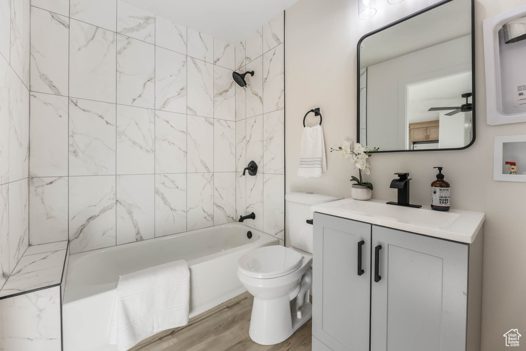 Full bath with vanity, toilet, shower / bathtub combination, and wood finished floors