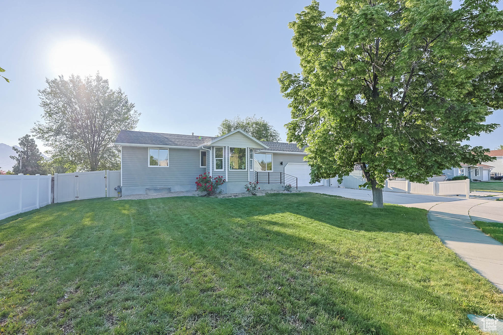 Ranch-style house featuring a gate, a garage, and driveway