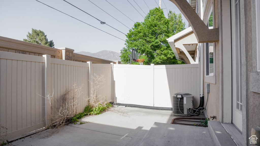 View of patio with central air condition unit, fence, and a mountain view