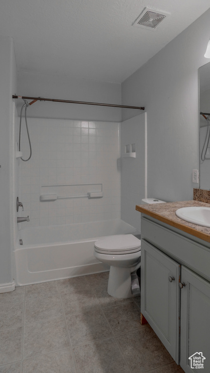 Bathroom with tile patterned floors, toilet, vanity, and shower / bathtub combination