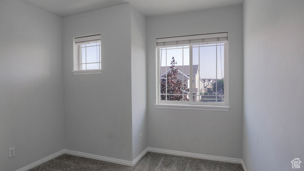 Carpeted empty room featuring baseboards