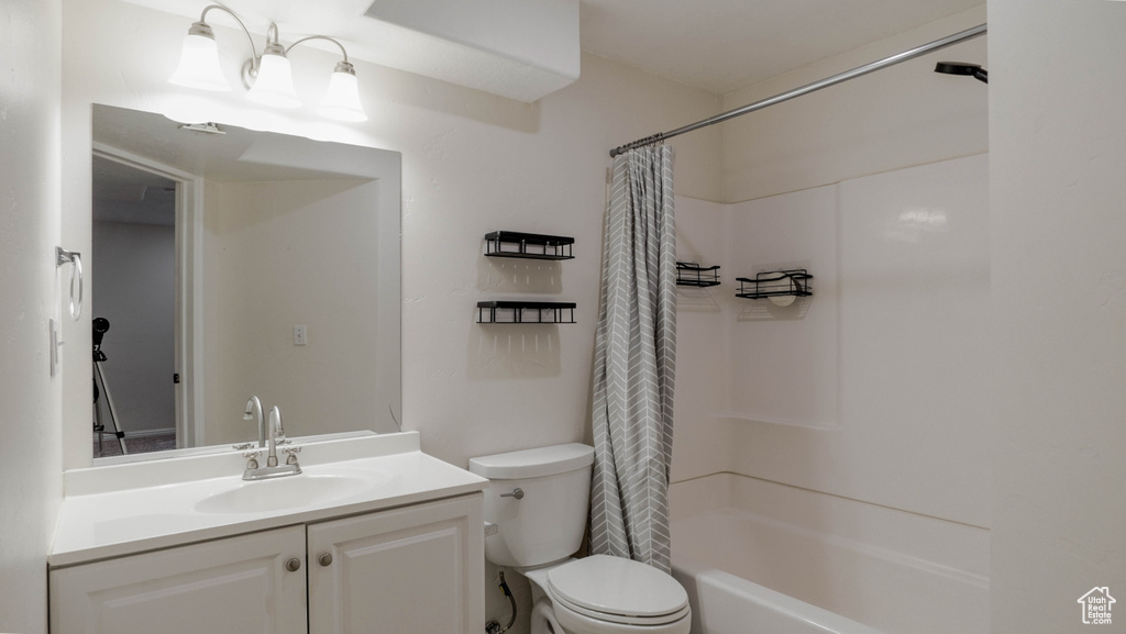 Full bath featuring toilet, vanity, and shower / bath combo with shower curtain