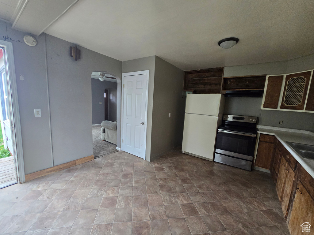 Kitchen featuring electric range, freestanding refrigerator, under cabinet range hood, a ceiling fan, and light countertops