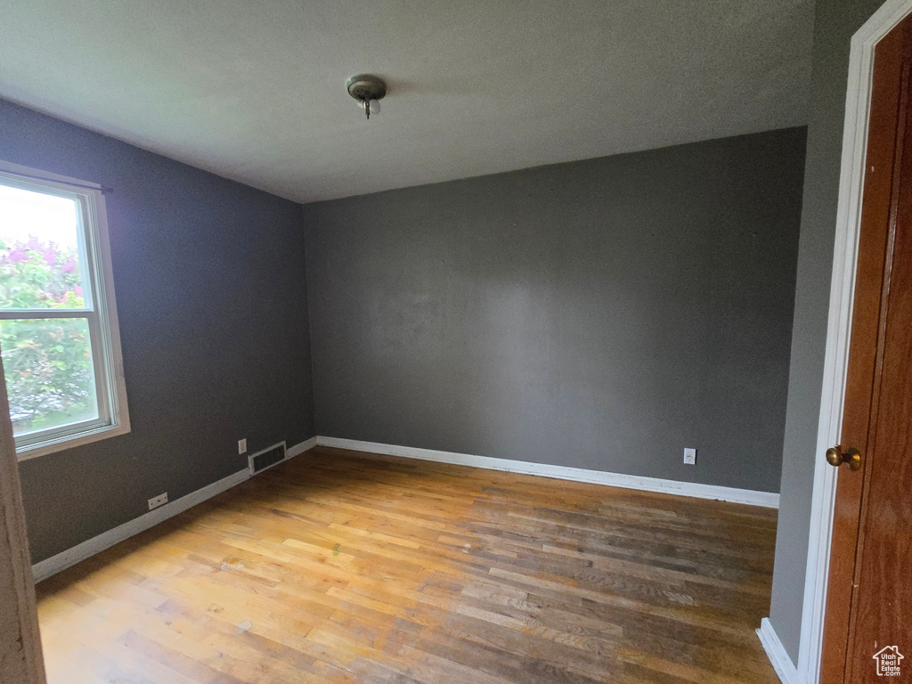 Spare room featuring wood finished floors and baseboards