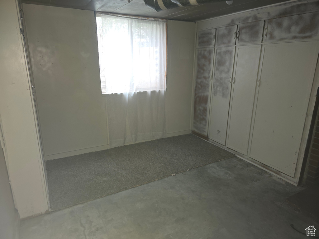Unfurnished bedroom featuring concrete flooring and a closet