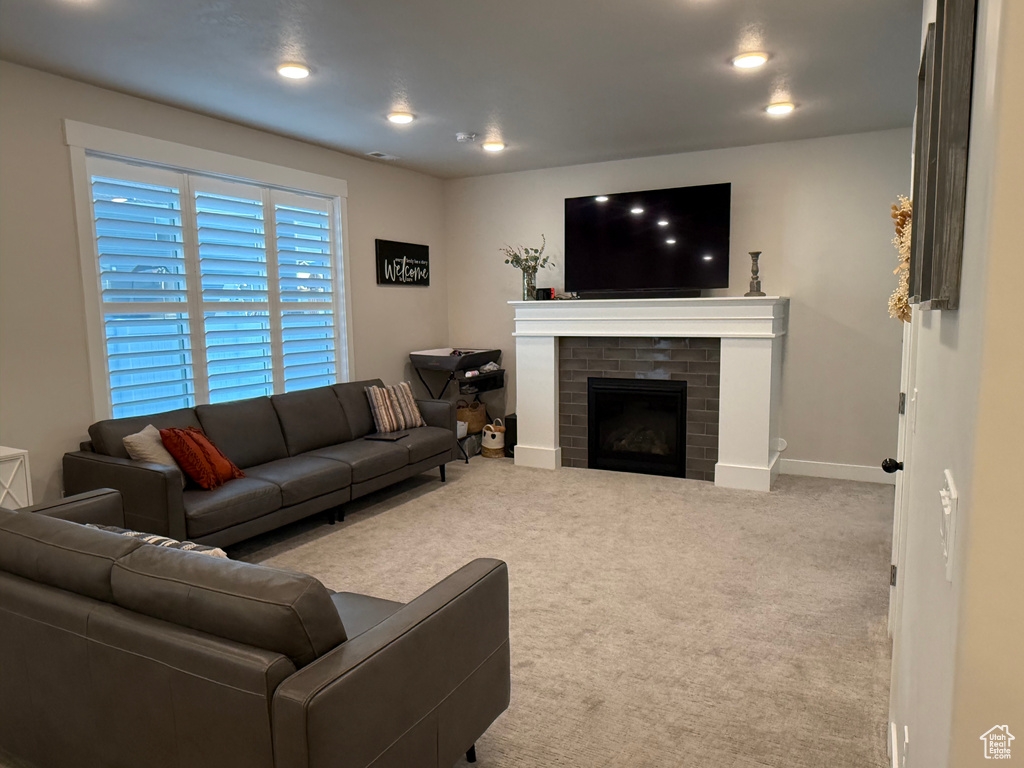 Living room with carpet floors, baseboards, a brick fireplace, and recessed lighting