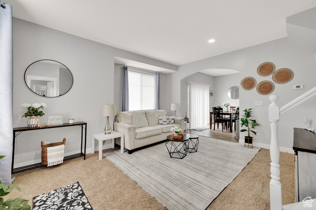 Living room featuring arched walkways, baseboards, and recessed lighting