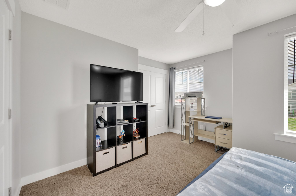 Carpeted bedroom with baseboards and a ceiling fan
