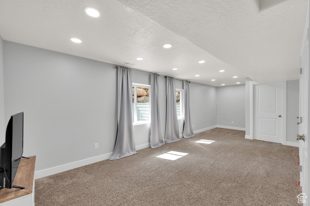Basement with recessed lighting, carpet flooring, a textured ceiling, and baseboards