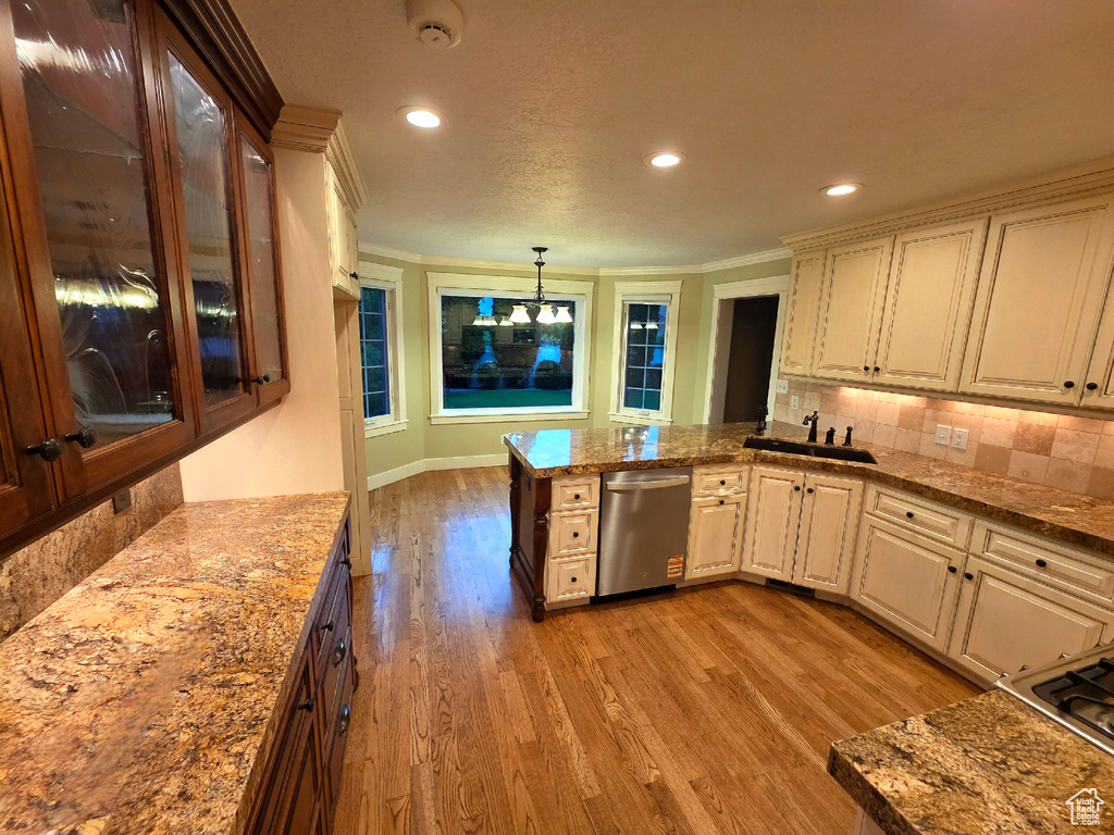 Kitchen with stainless steel dishwasher, light wood-style floors, recessed lighting, backsplash, and a sink
