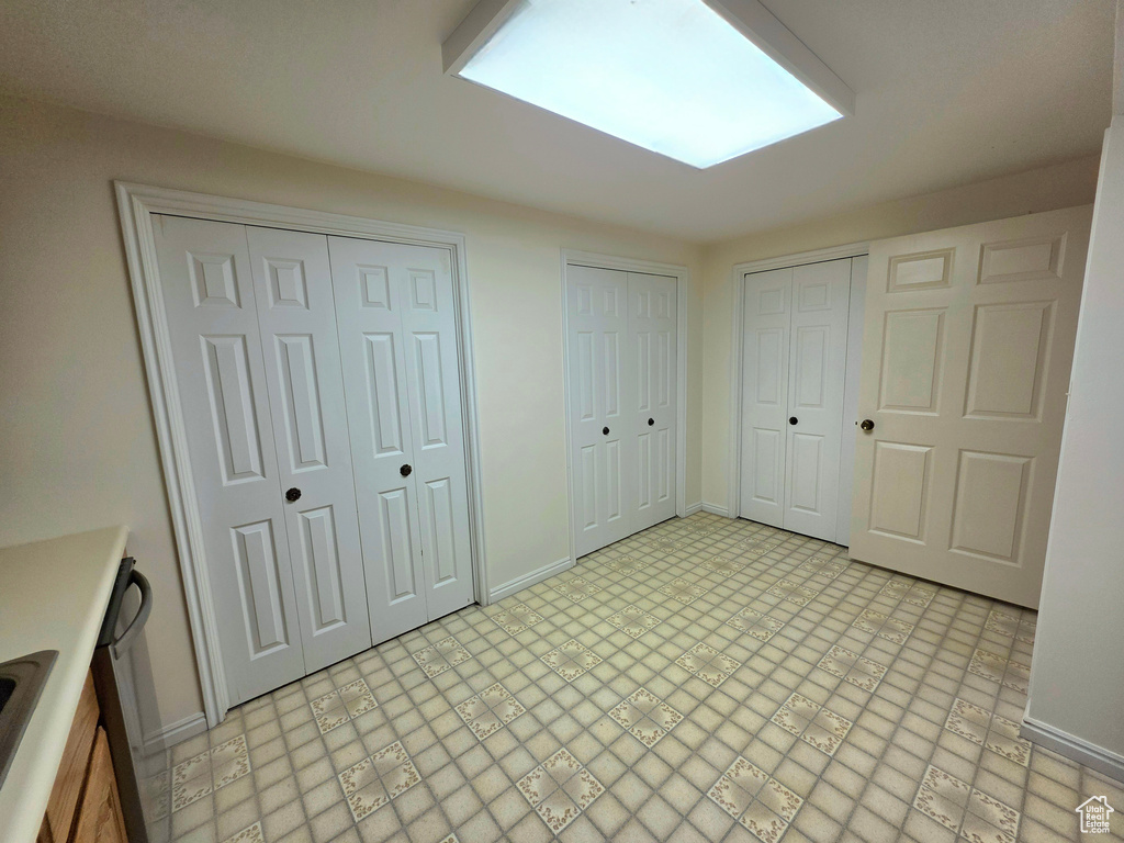 Unfurnished bedroom featuring two closets and baseboards