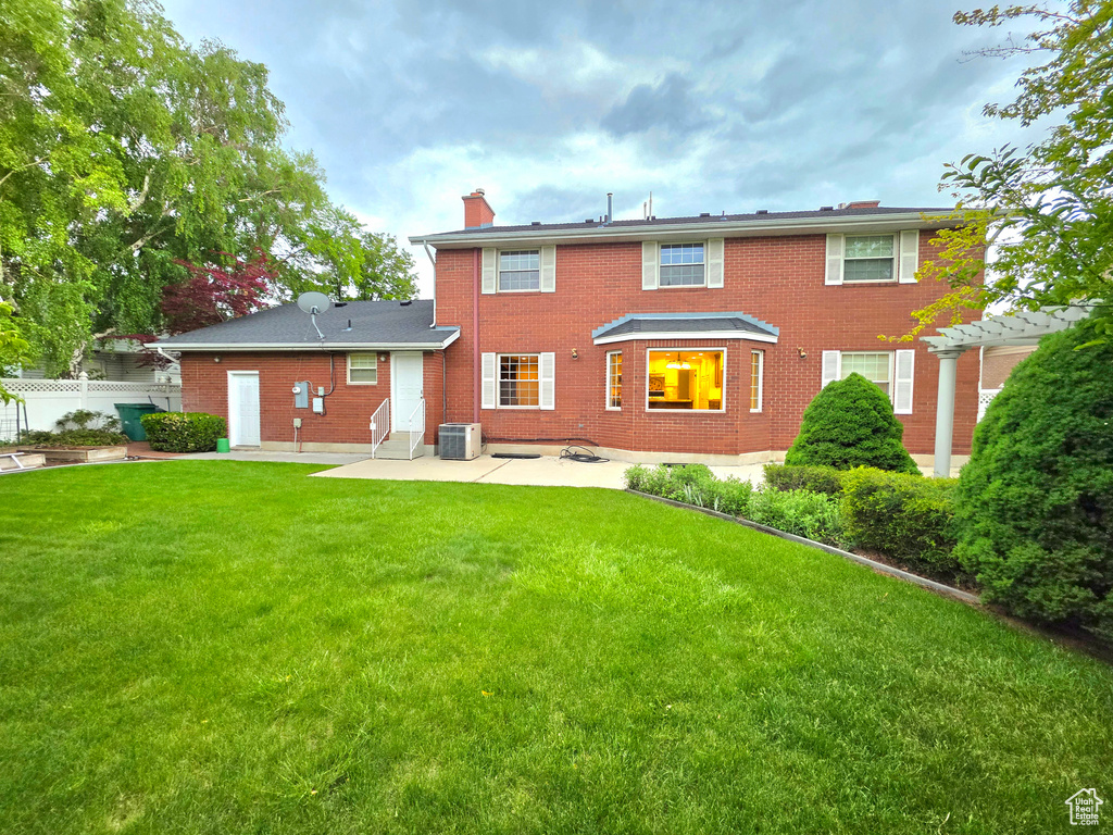 Back of property featuring a chimney, a patio area, brick siding, and central air condition unit