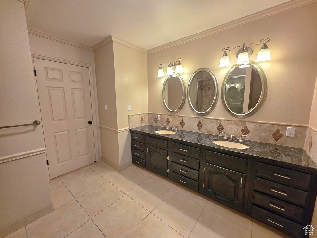 Full bathroom featuring tile patterned floors, double vanity, and crown molding