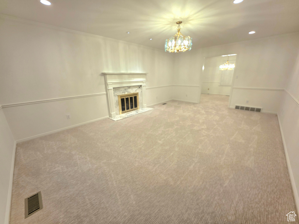 Unfurnished living room with a chandelier, recessed lighting, light colored carpet, a fireplace, and baseboards