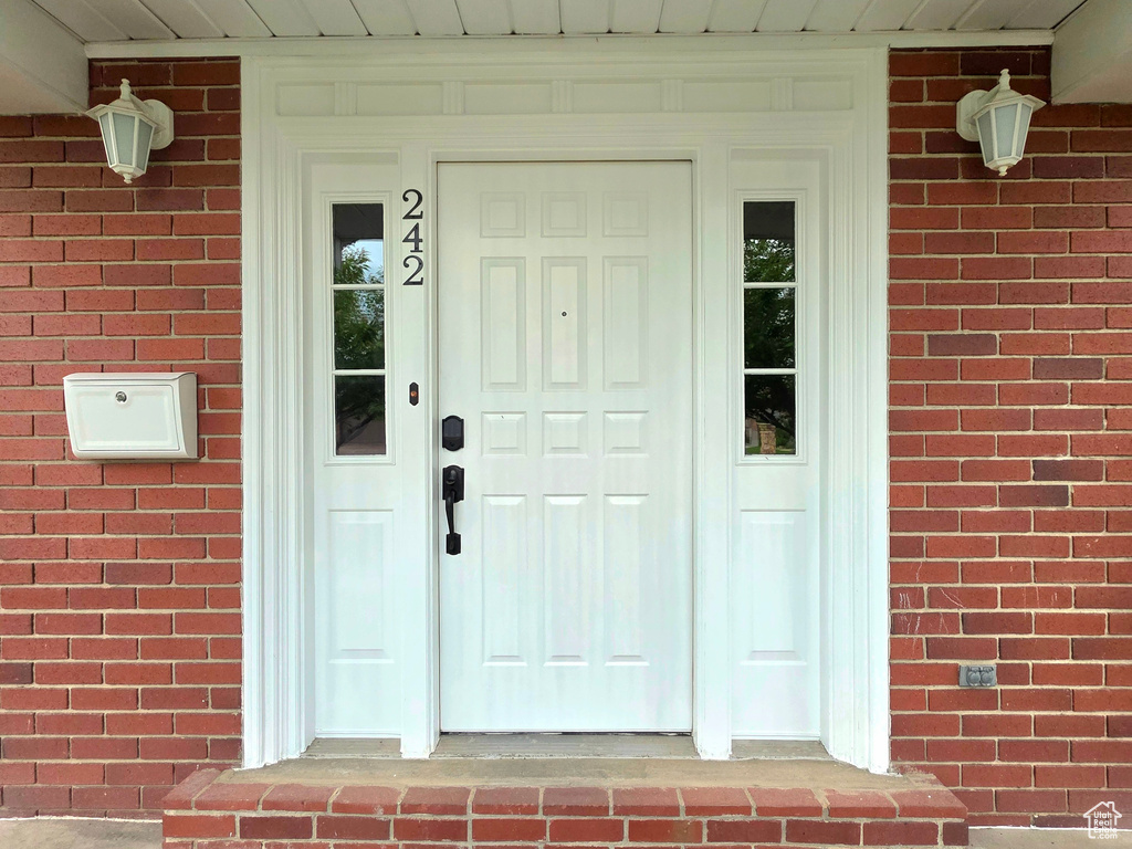 Property entrance featuring brick siding