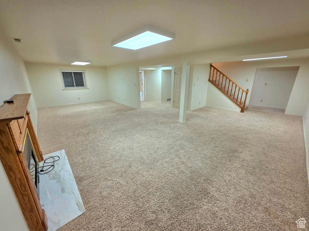 Finished basement featuring stairway and carpet floors