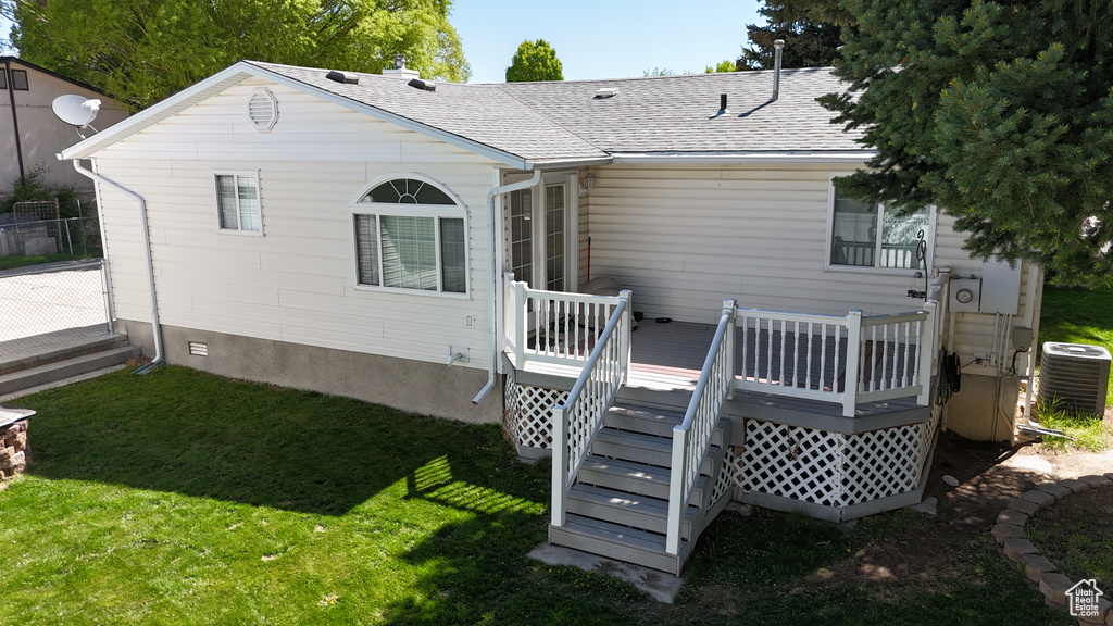 Rear view of property with central AC, a lawn, a wooden deck, a shingled roof, and stairway