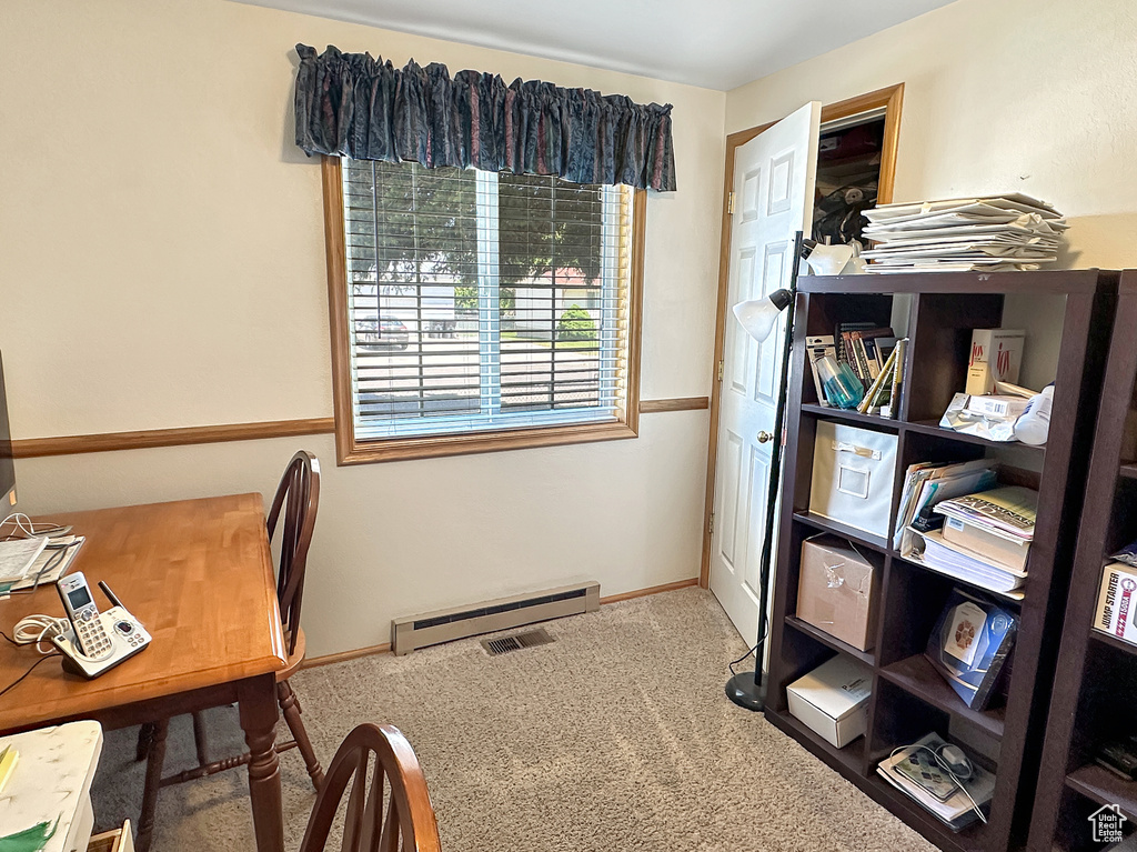 Carpeted office with a baseboard heating unit