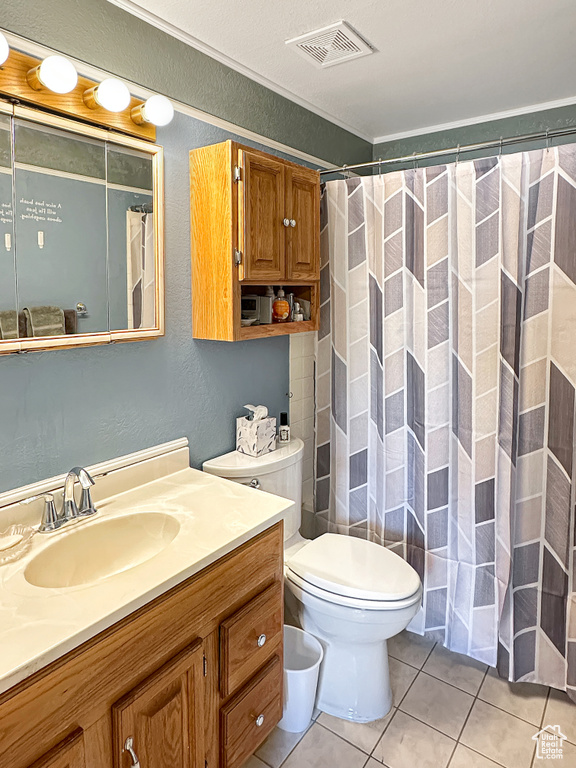 Full bathroom featuring tile patterned flooring, vanity, toilet, a shower with shower curtain, and ornamental molding